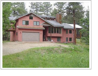 large house surrounded by woods