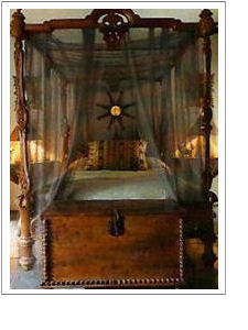 four-poster bed with wooden footlocer